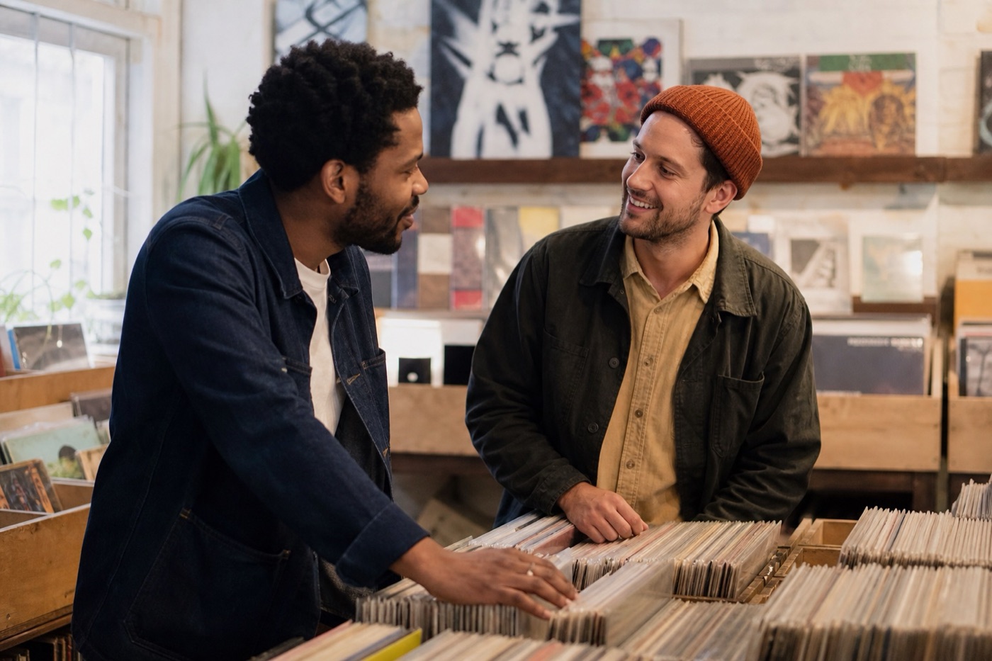 Two adult men talking while browsing a record shop on a relaxed date